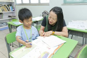 导师协助学童解决功课上的难题，培养学习兴趣。